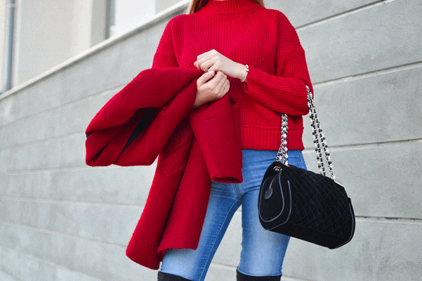 Woman-wearing-red-sweater-with-blue-skinny-jeans.
